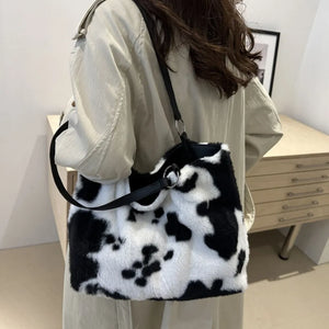 Cowhide print faux fur shopper bag with black trim and silver hardware.