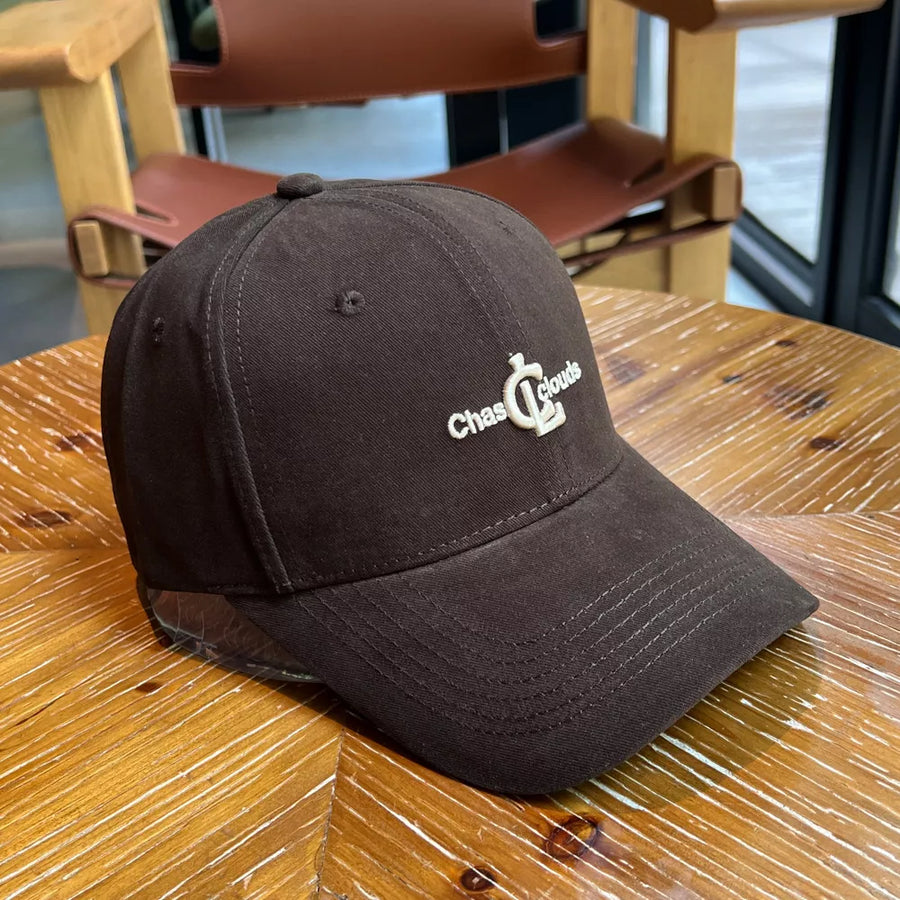 Brown baseball cap with white embroidered logo and adjustable strap