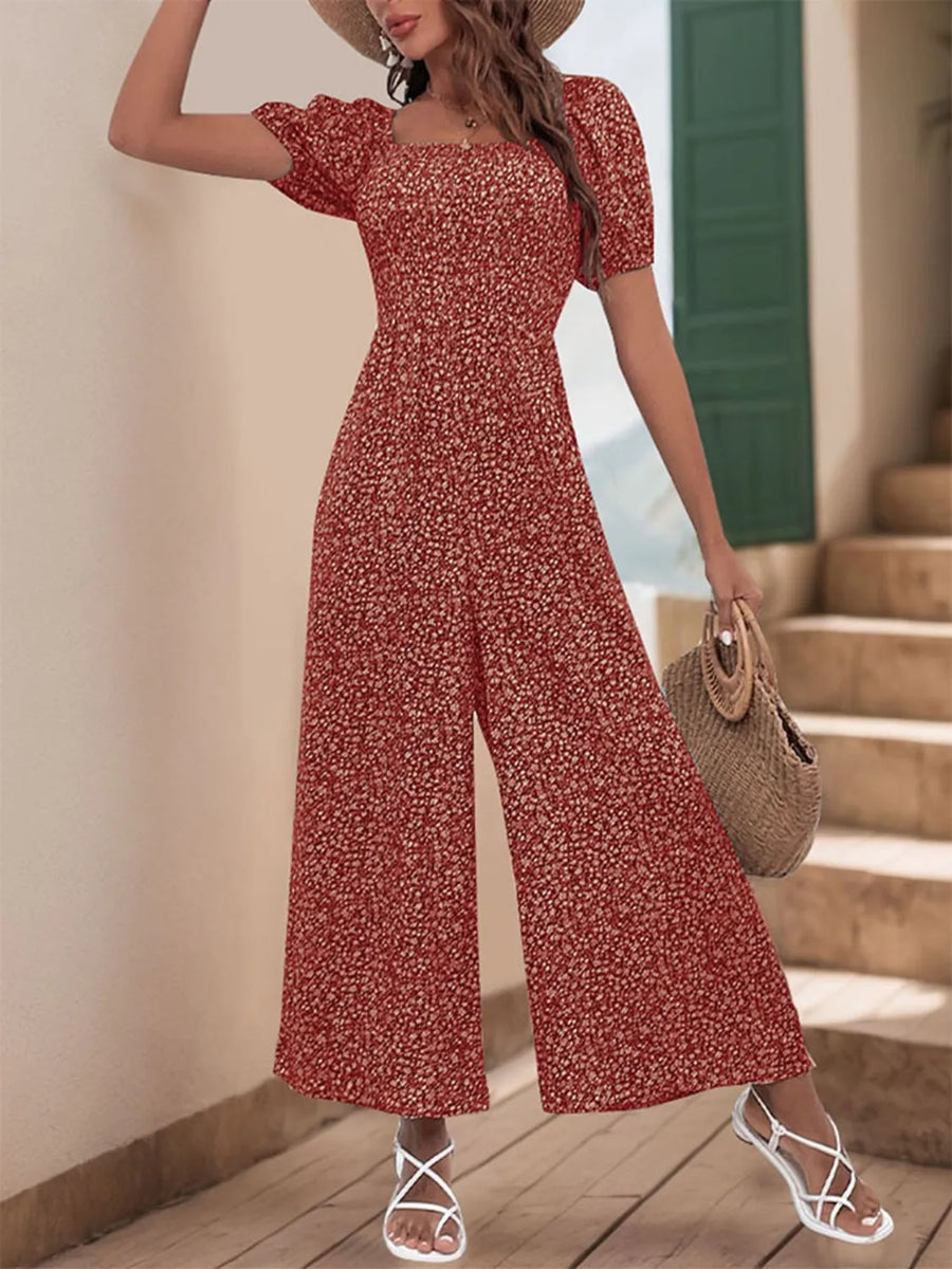 Smocked bodice floral print jumpsuit with puff sleeves and wide legs.