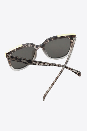 Leopard print angular frame sunglasses with light gray accents and dark lenses.