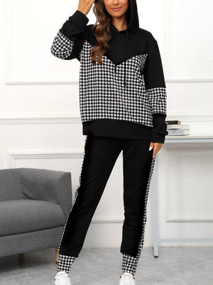 Black houndstooth hoodie and pants set with drawstring and patterned cuffs and side stripes.