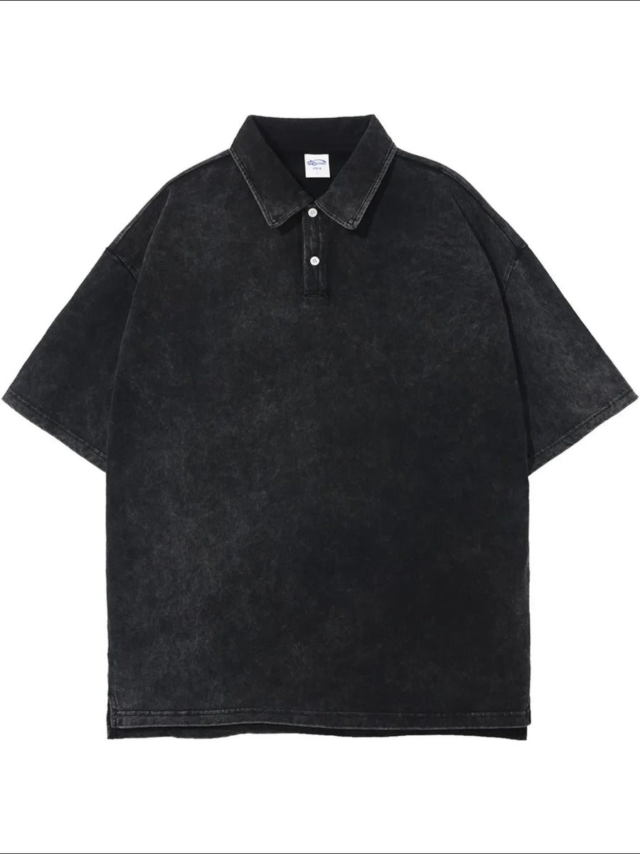 Oversized black washed polo shirt with short sleeves and a two-button placket.