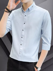 Men's light blue cotton button-down shirt with black buttons and embroidered collar detail.