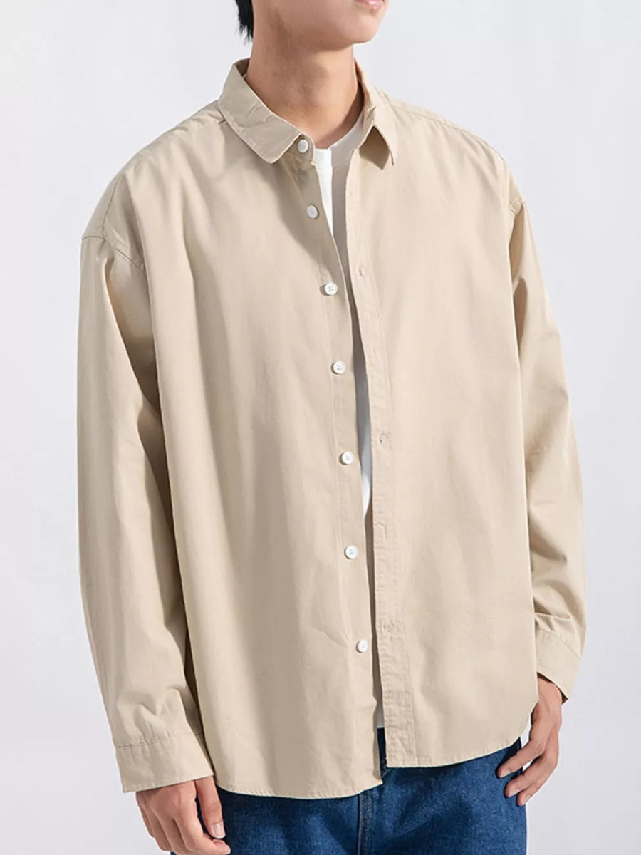 Men's camel long sleeve button-up shirt with white buttons, styled casually.