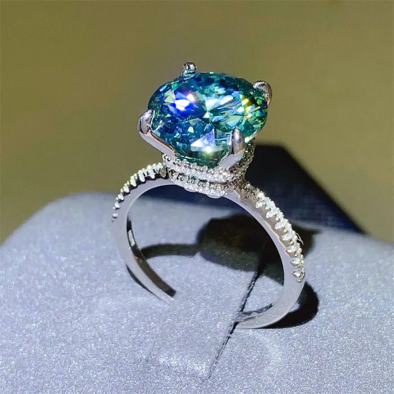 Radiant teal moissanite pavé ring in silver with a large center stone and diamond-accented band.
