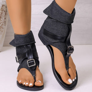 Denim-accented buckle sandals in black with ankle cuff and strap details.