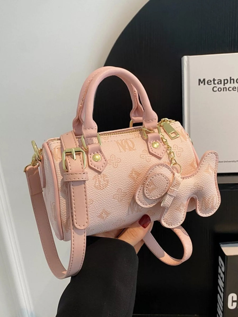 Pink mini barrel crossbody bag with all-over monogram print and dog charm detail