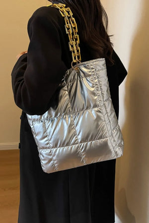 Silver quilted nylon tote bag with a chunky gold chain strap.
