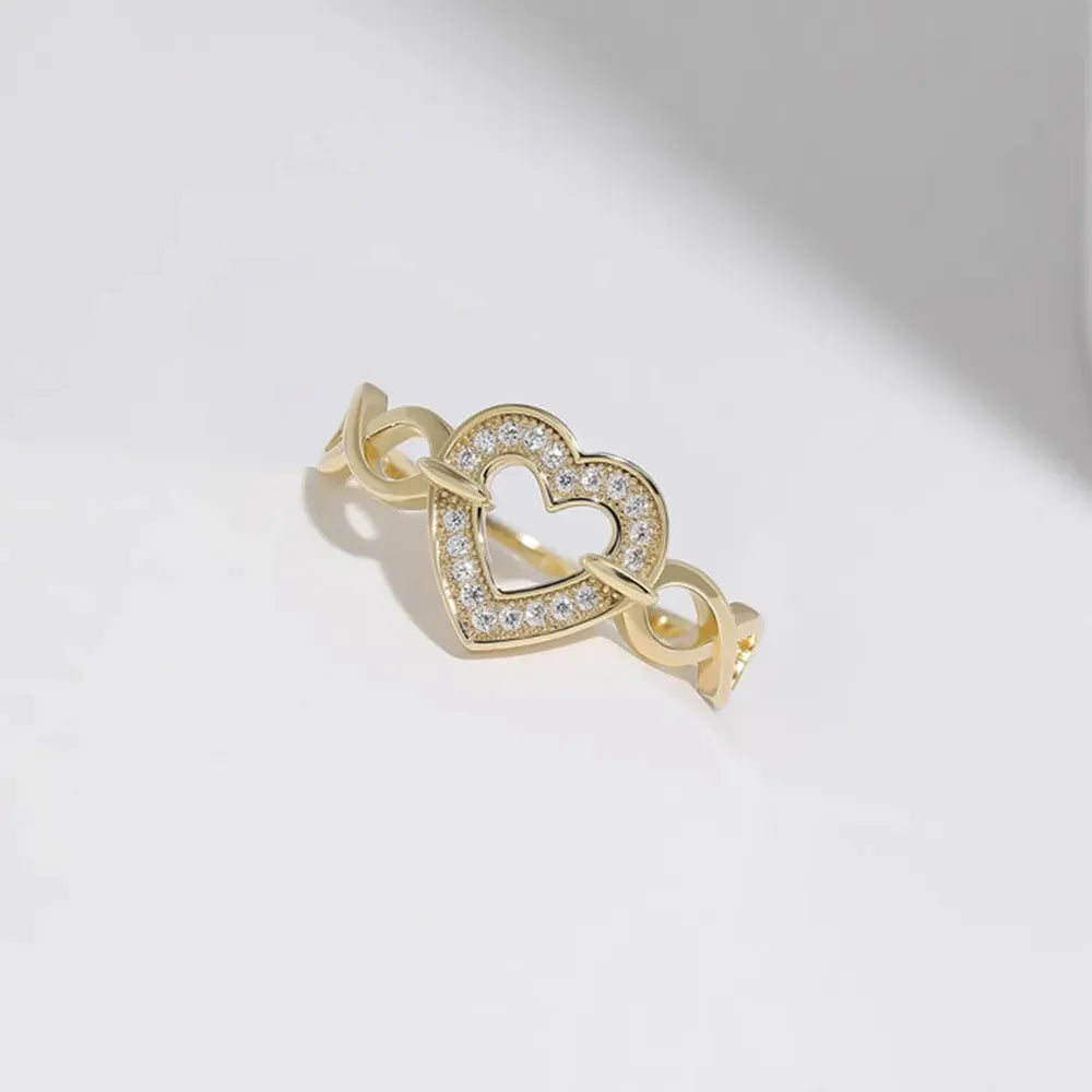 Gold ring with intertwined band and pavé crystal heart detail