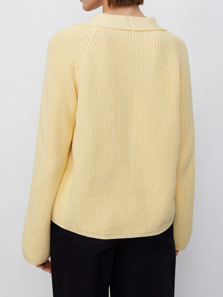 Yellow ribbed raglan cardigan with deep V-neck and button details.