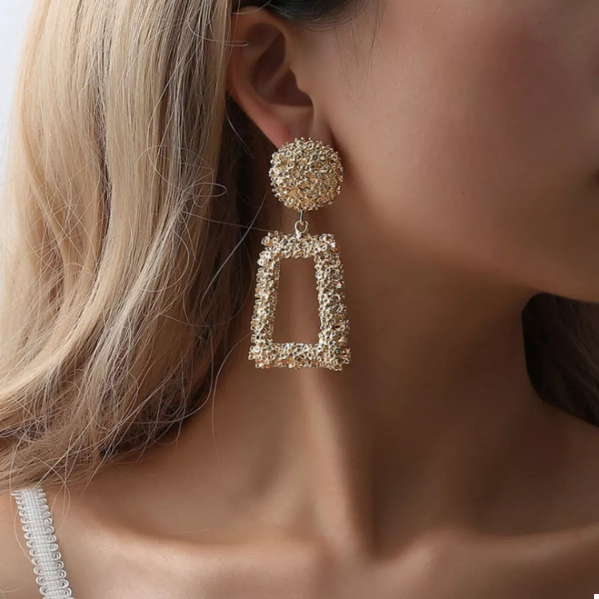 Gold geometric dangle earrings with textured finish and rectangular drop