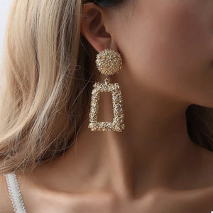 Gold geometric dangle earrings with textured finish and rectangular drop