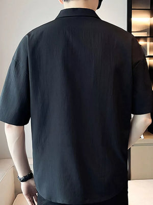 Black cotton polo shirt with short sleeves and a relaxed fit.