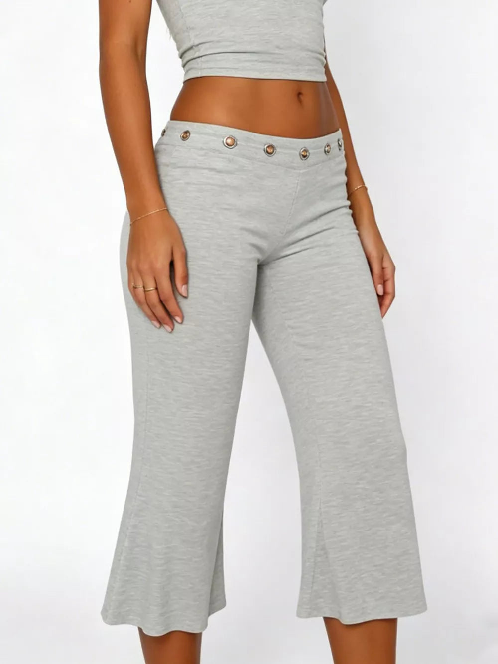 Light gray flared hem capri pants with button detail at the waist