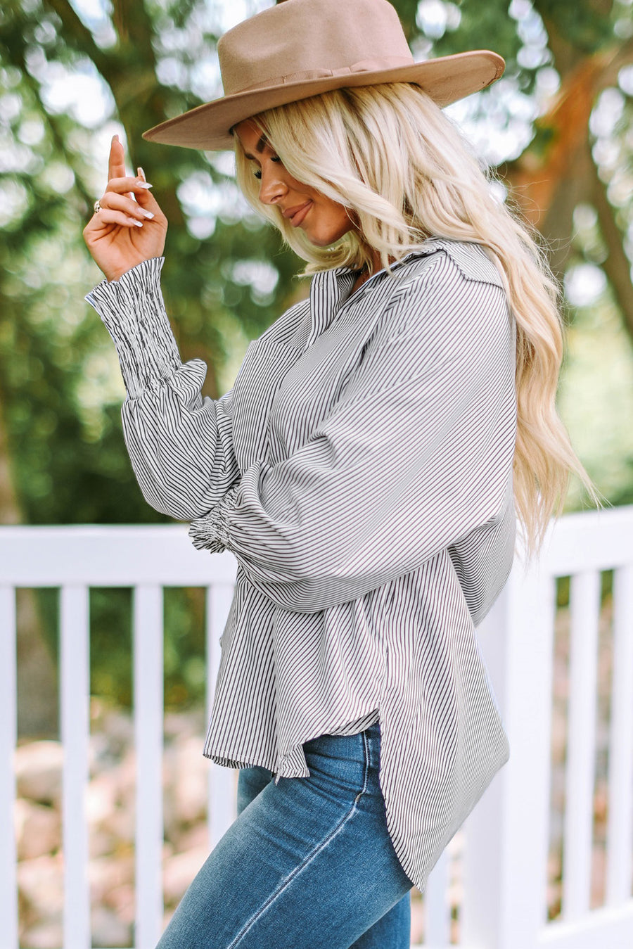 Pinstripe blouse with balloon sleeves and smocked cuffs, styled with jeans.