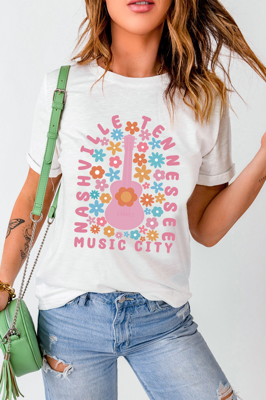 White t-shirt with Nashville Tennessee Music City graphic featuring a pink guitar and colorful flowers.