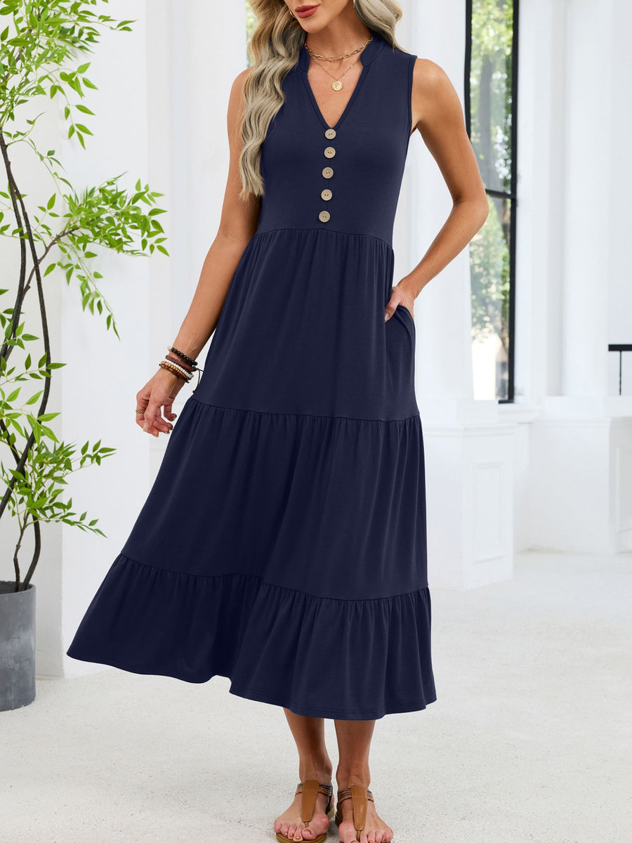Navy tiered midi dress with notched V-neck and decorative buttons, sleeveless with pockets.