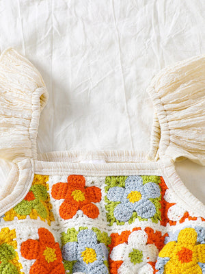 Crochet baby jumpsuit with floral squares and ruffled sleeves