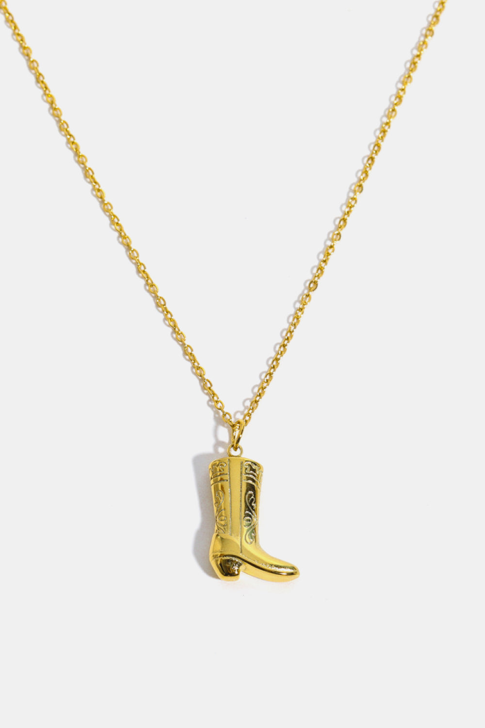 Gold cowboy boot charm necklace with ornate detailing on a delicate chain.