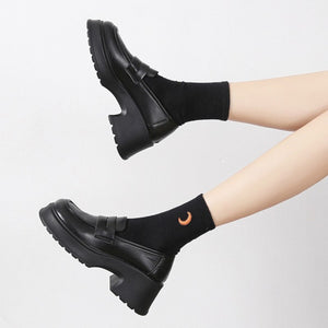 Black round toe block heel loafers with chunky sole and moon socks.