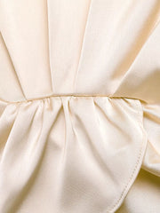 Champagne satin twist-front top detail with ruched waist and flowing pants fabric.