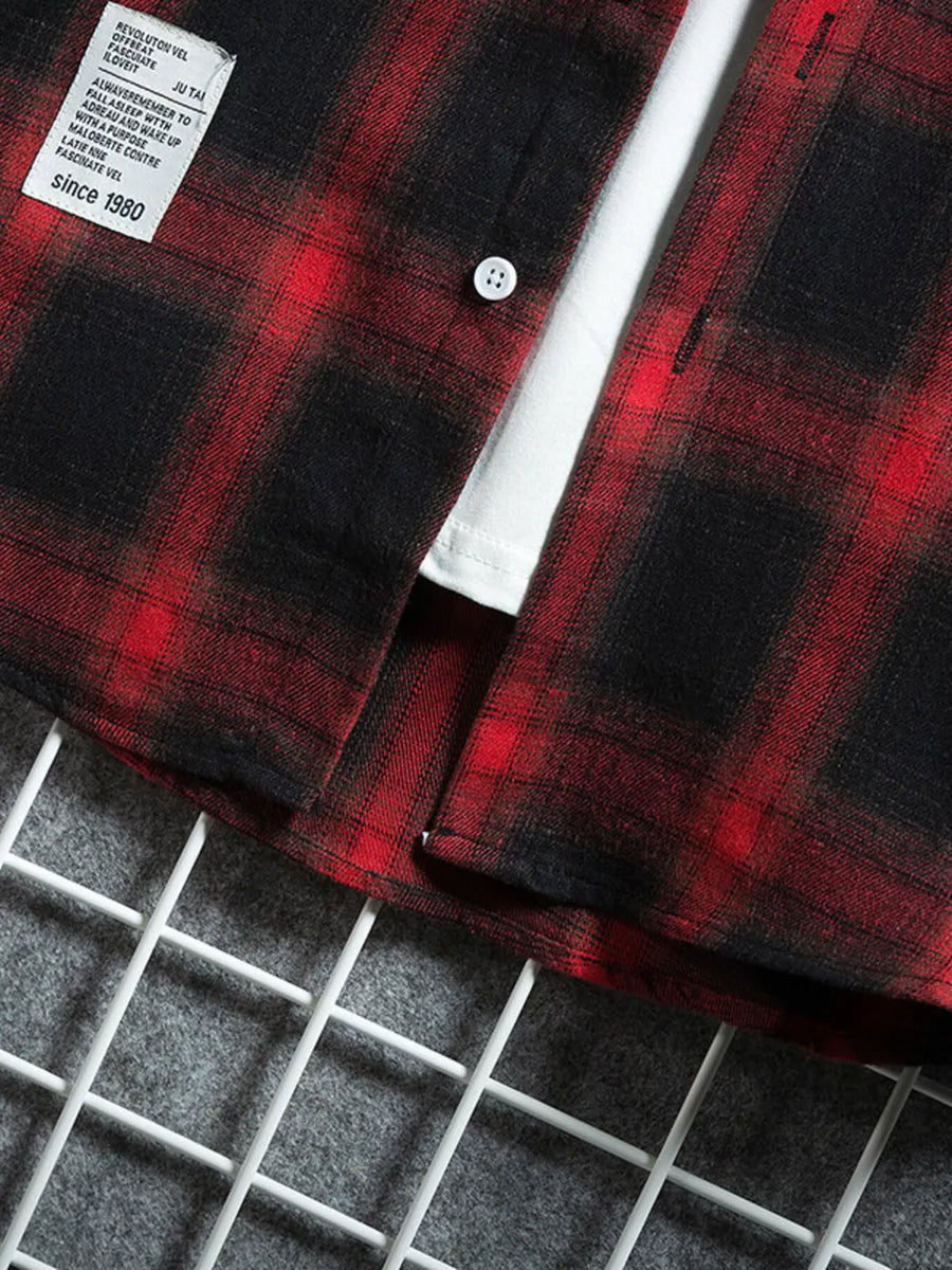 Red and black plaid short-sleeve cotton shirt with white undershirt and chest pocket detail.