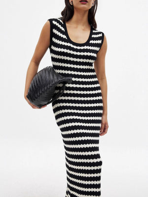 Striped scoop neck midi knit dress with side slit, held with a black woven clutch.