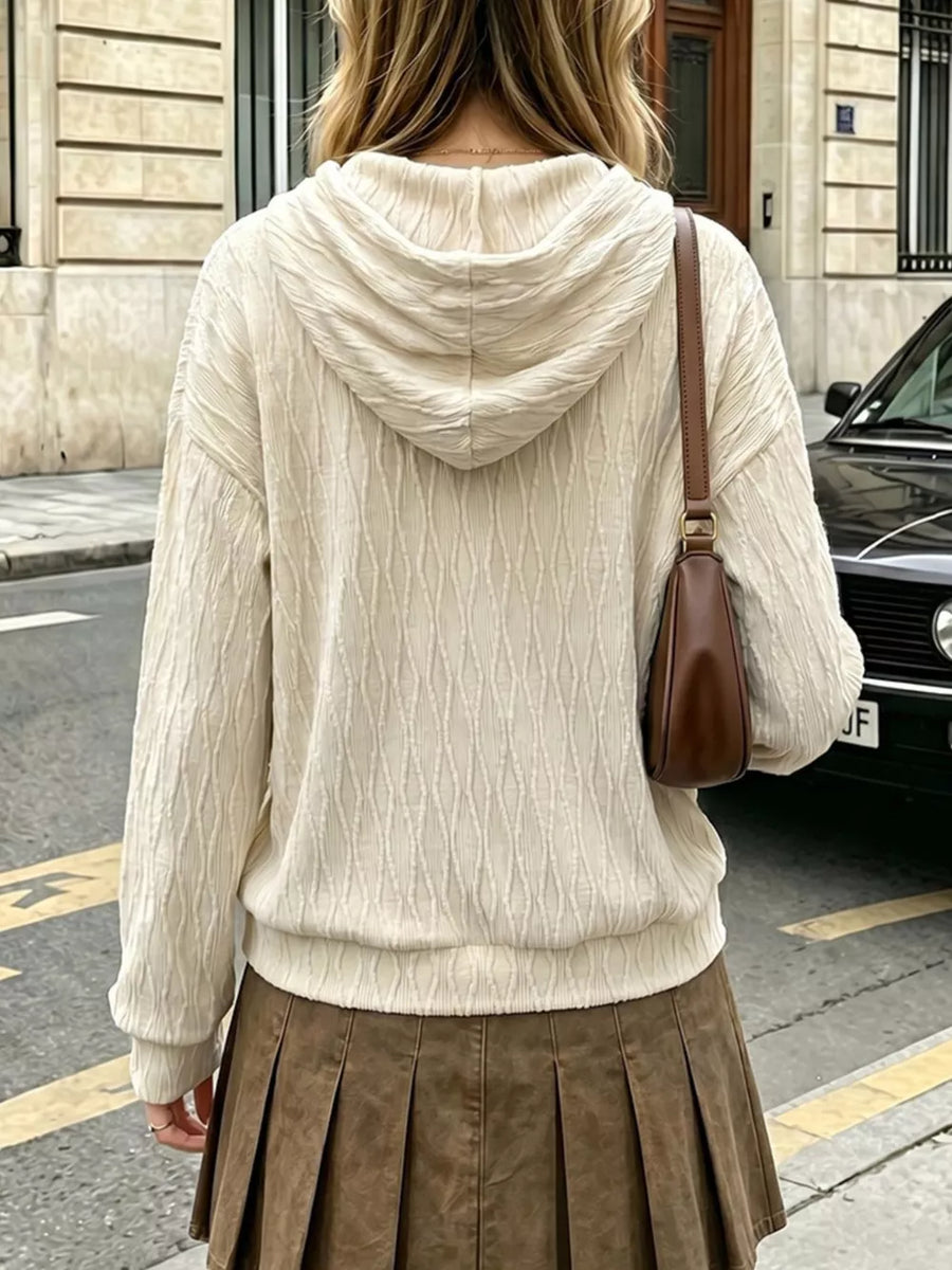 Textured cream hoodie with dropped shoulders and drawstring hood.