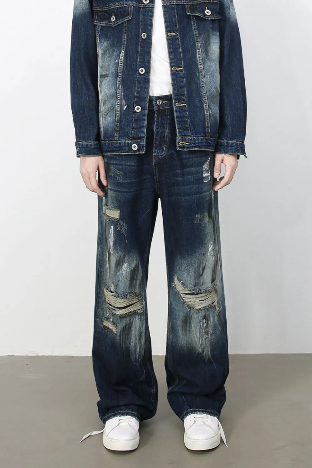Oversized distressed dark wash denim jeans with wide legs and ripped details.