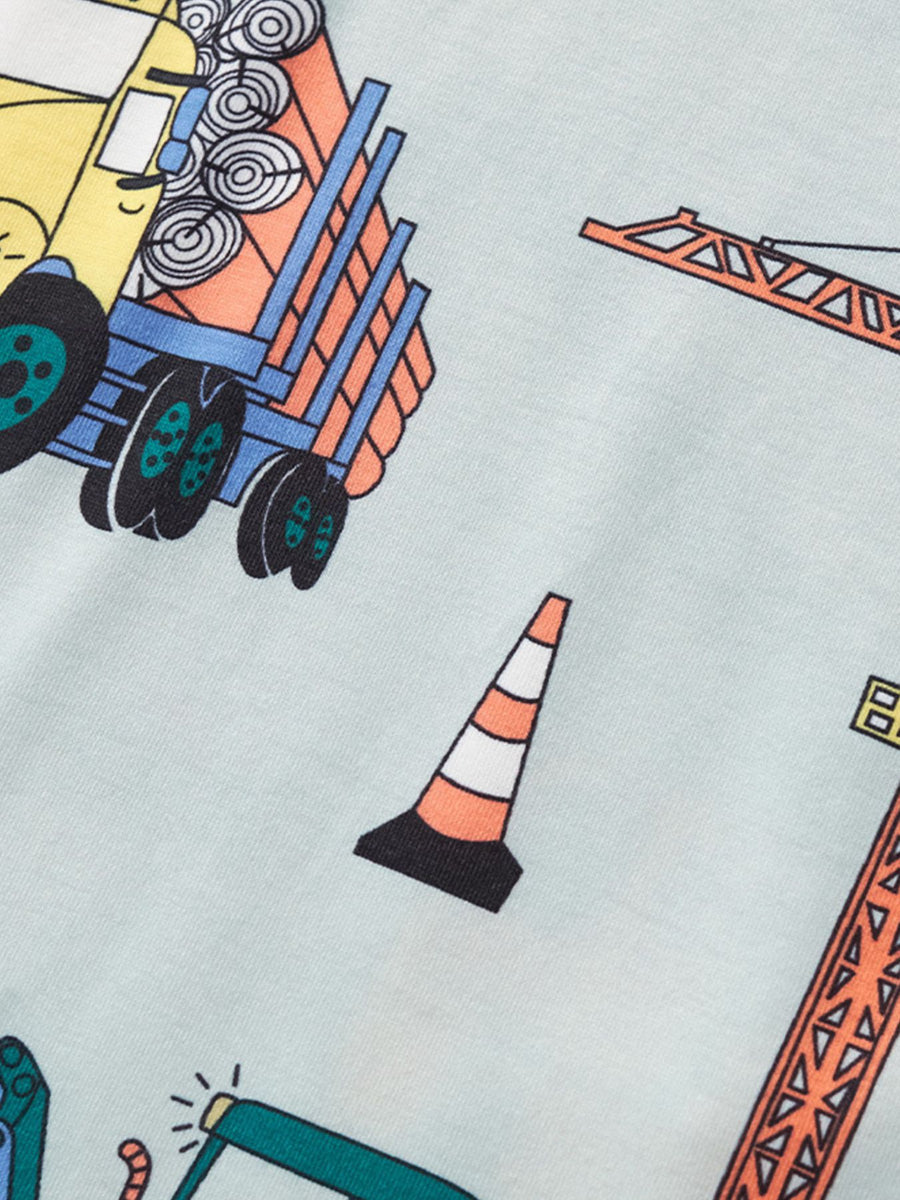 Toddler t-shirt with construction vehicle print, featuring a dump truck, crane, and traffic cone on a light blue background.