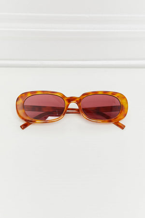 Tortoiseshell oval sunglasses with burgundy sunset lenses and a classic fit.
