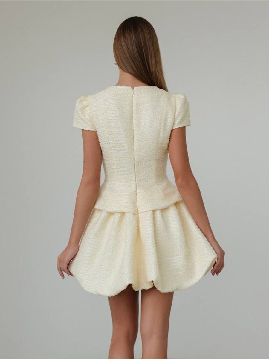 Textured cream tweed dress with short puff sleeves and bubble hem skirt.
