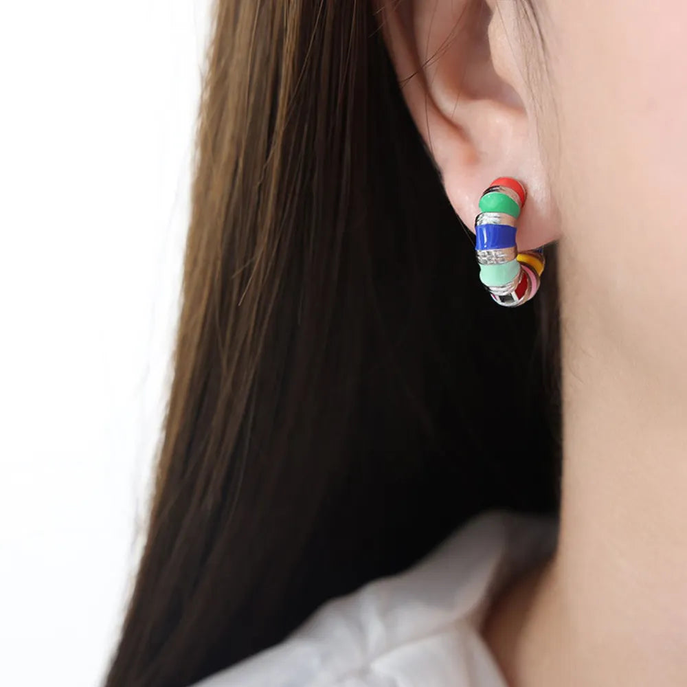 Rainbow enamel segmented hoop earrings in silver with colorful segments.