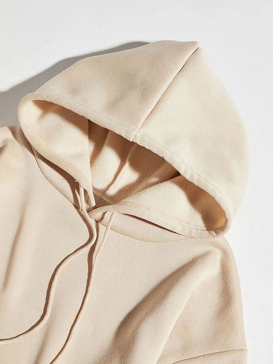 Cream hoodie with adjustable drawstring hood and fleece lining detail.