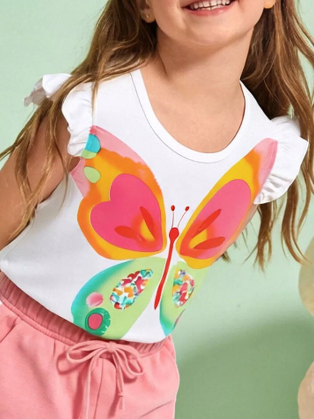 White cotton t-shirt with ruffle sleeves and a colorful butterfly graphic.