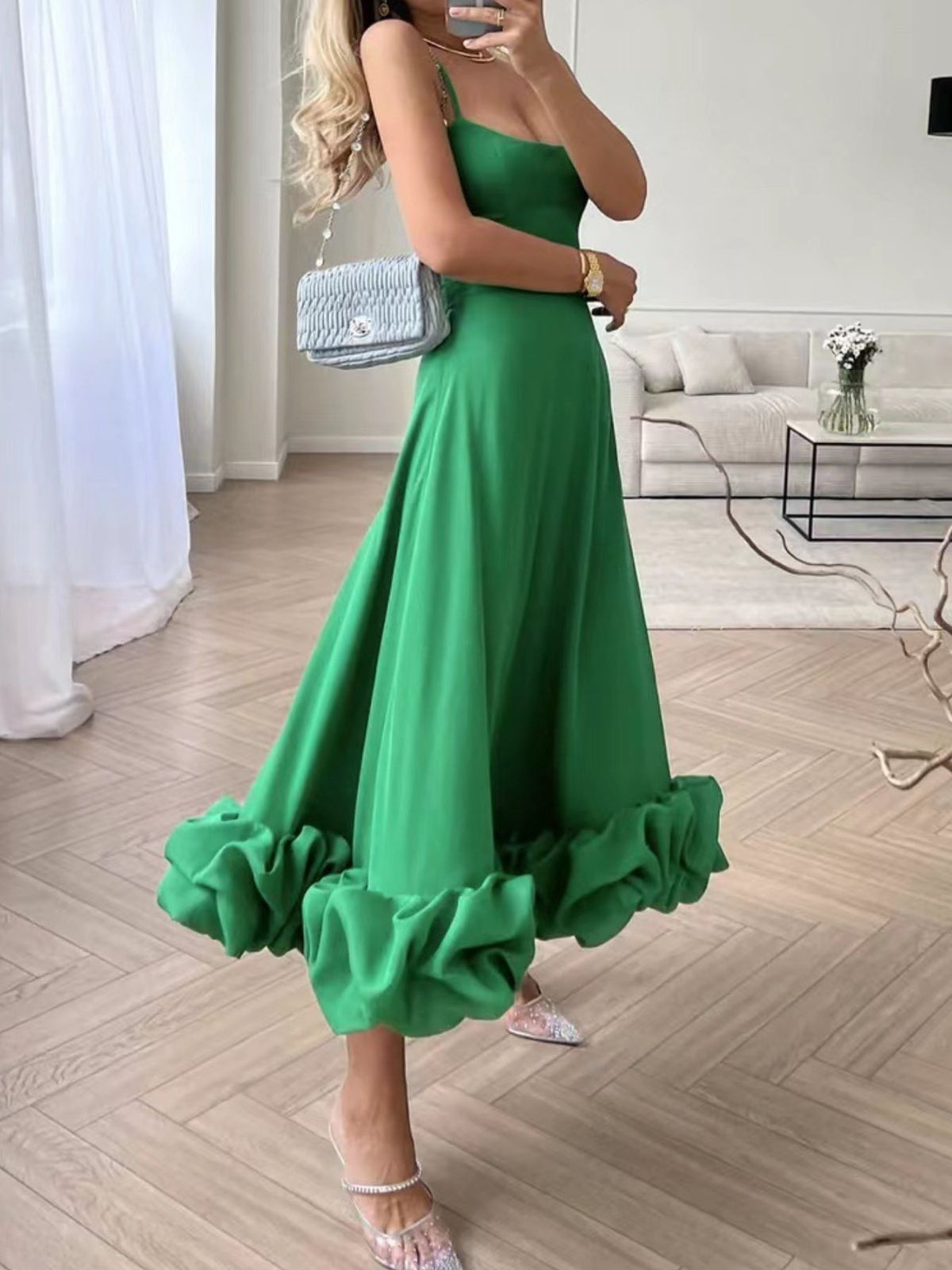 Green midi dress with ruffle hem and spaghetti straps, styled with sparkly heels.