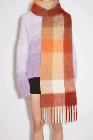 Checked plaid winter wrap scarf with fringe in orange, brown, and cream colors.