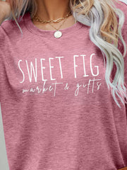 Blush pink graphic t-shirt with white "Sweet Fig Market & Gifts" text.