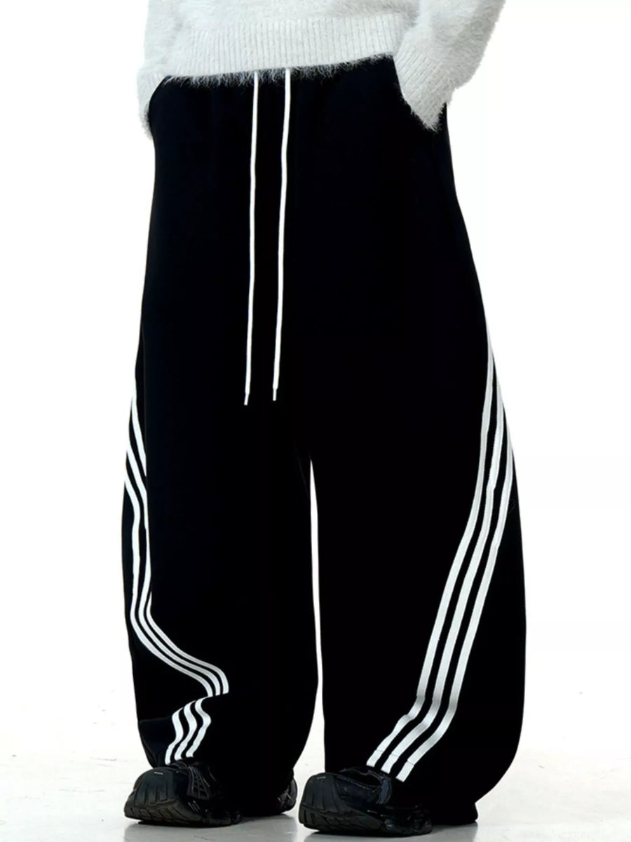 Men's black wide-leg sweatpants with white side stripes and drawstring waist.