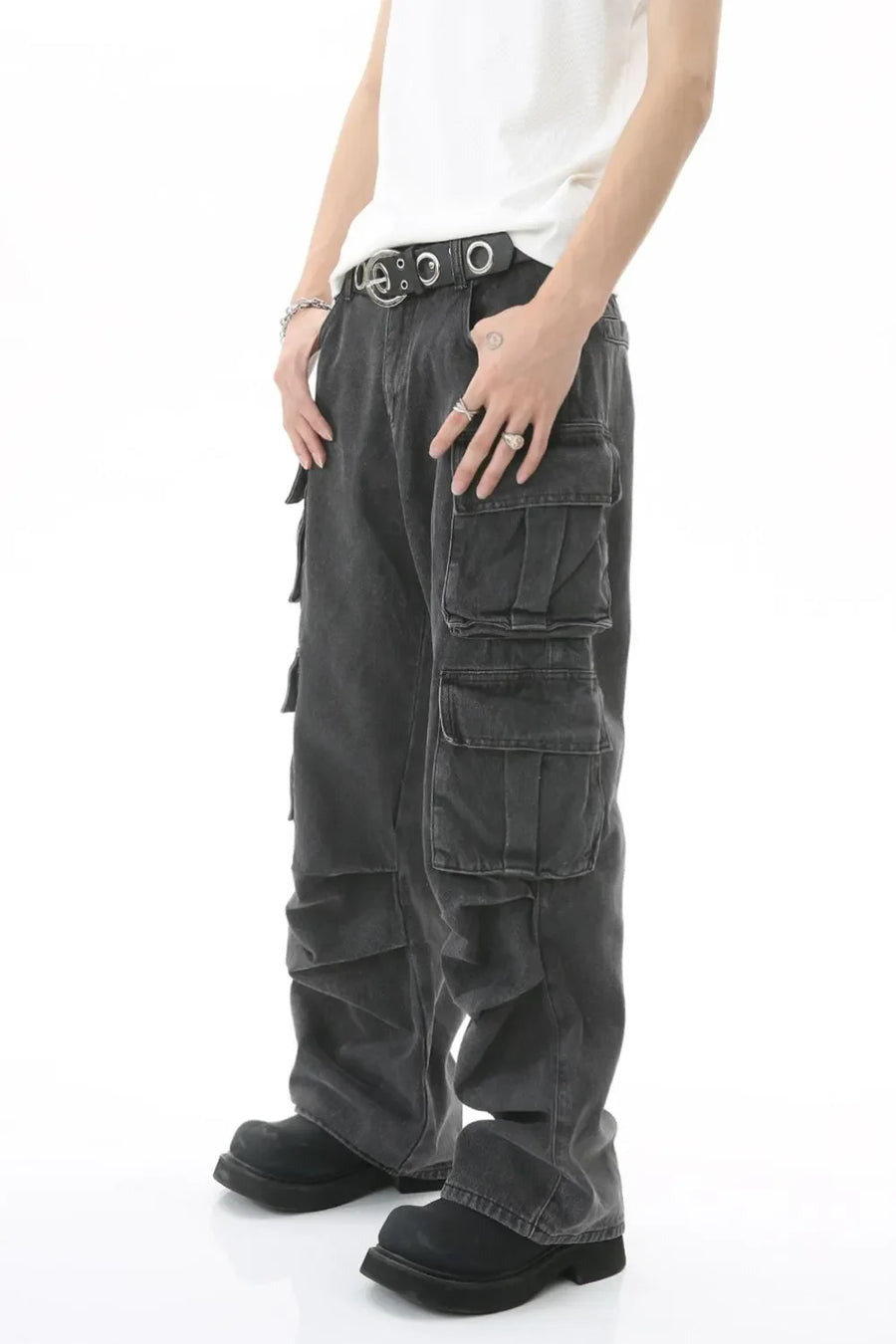 Baggy dark wash denim cargo pants with multiple pleated pockets and a belted waist.