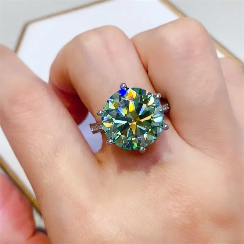 Prismatic cut solitaire ring in silver with a large, bright green gemstone and small accent stones.