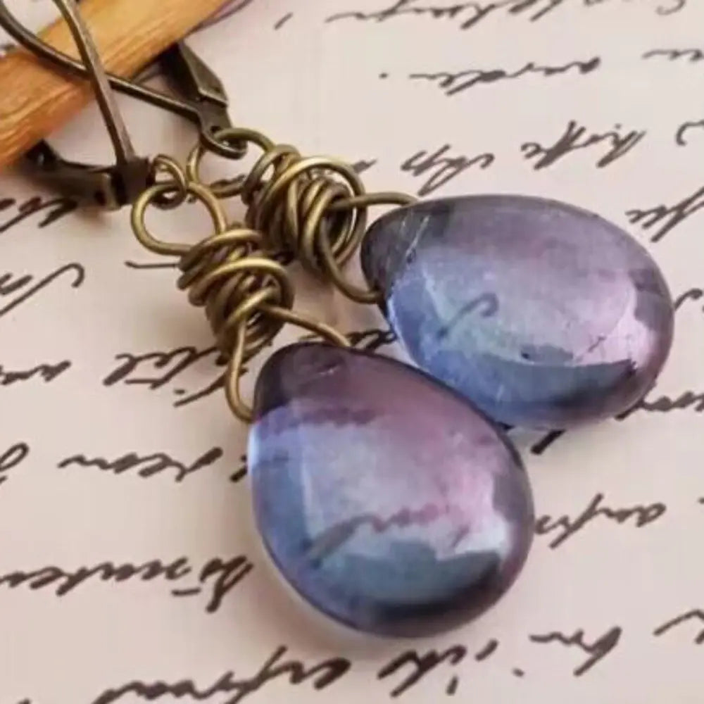 Wrapped wire teardrop earrings in blue purple with antique brass findings.