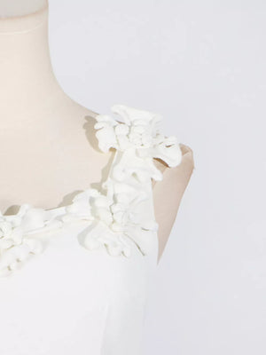 White dress with floral applique straps and a V-neckline.