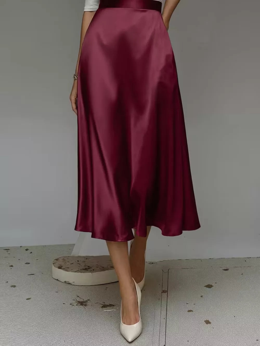 Elegant A-line satin skirt in wine red with pockets, midi length.