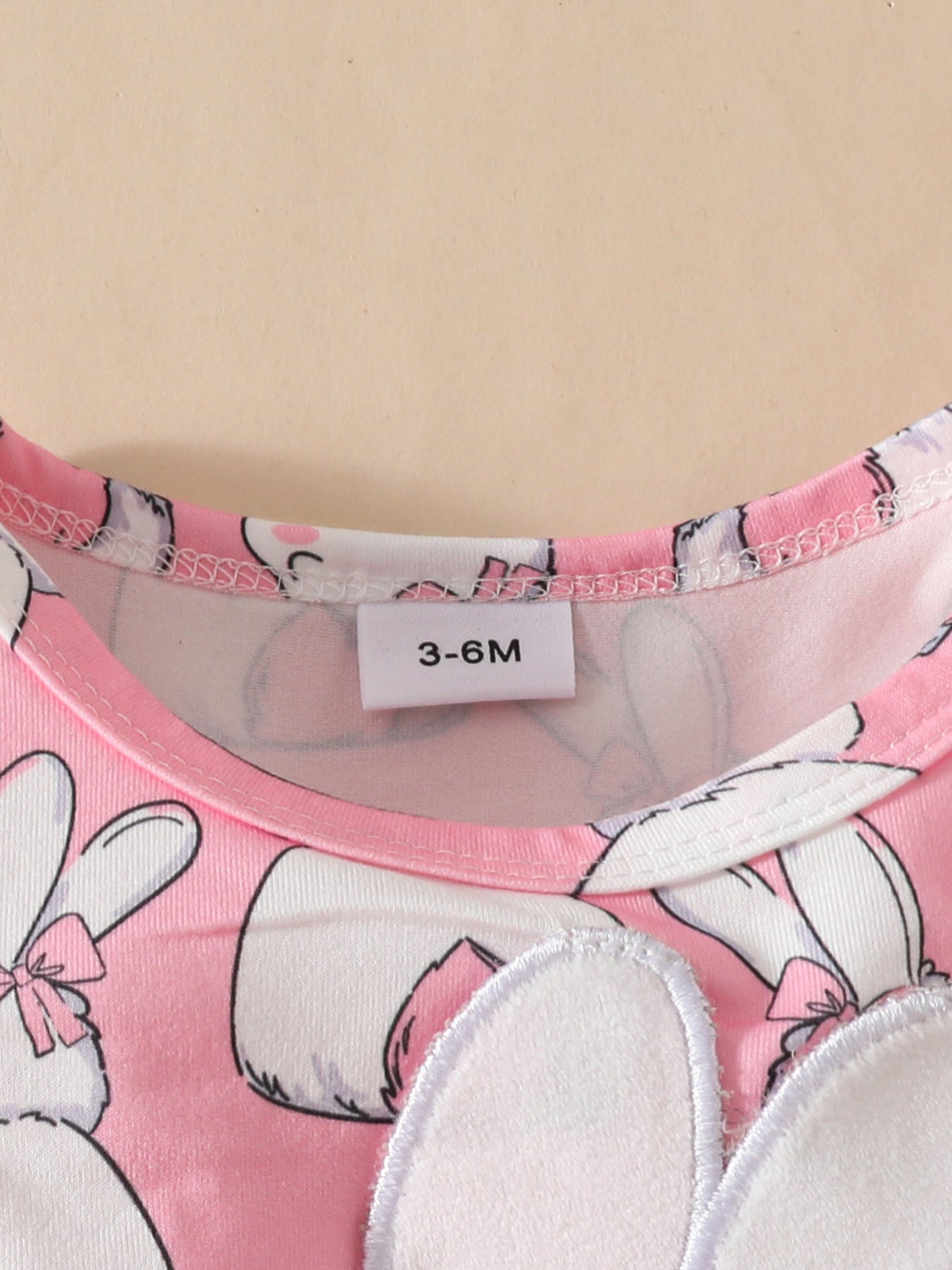 Pink baby dress with bunny applique and bow detail, size 3-6M tag visible.