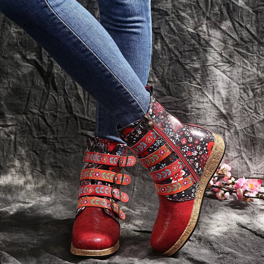 Red ankle boots with floral embroidery and decorative straps, featuring side zippers and a suede-like finish.