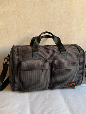 Chic medium plaid duffel bag with two front pockets and adjustable strap.