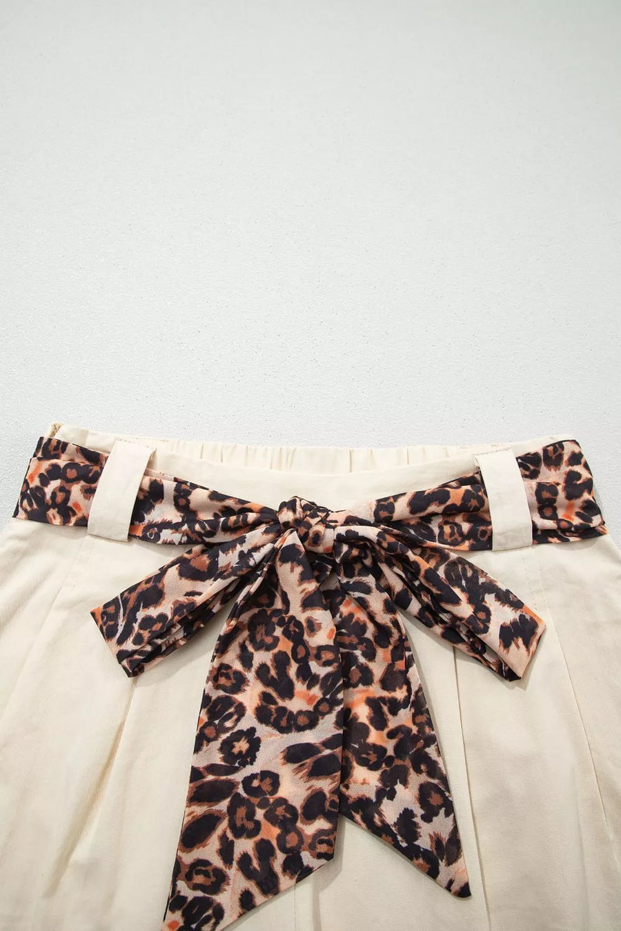 Cream pleated skirt with leopard print tie-waist belt and bow detail