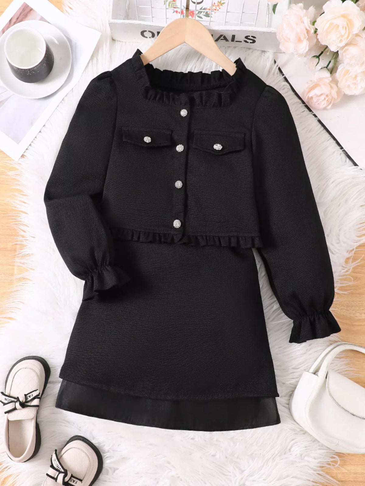 Black ruffle trim top and skirt set with pearl buttons and pocket details.