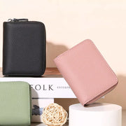 Pebbled mini leather card wallet in dusty pink and black with zip closure.